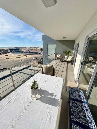 a balcony with a white table and a view of the airport at Atlantic Dunes No 14 in Walvis Bay