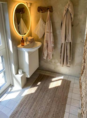 a bathroom with a sink and a mirror at Jeres Eget Private Retreat Tæt På Vandet in Dronningmølle