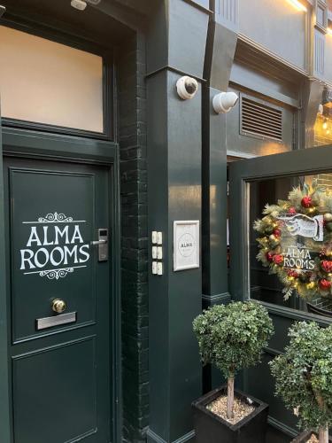 a green door with aania rooms sign on a building at The Alma Rooms in London