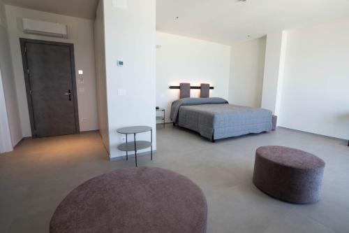 a bedroom with a bed and a table and a stool at Hotel Il Caminetto in Porto San Giorgio