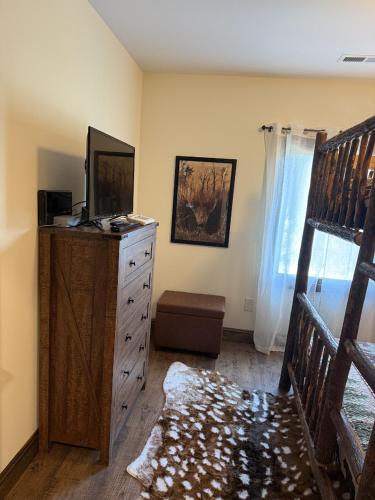 a bedroom with a dresser with a bed and a window at The Ancient Bears Den By Avada Properties in Union Grove