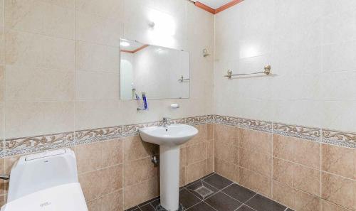 a bathroom with a sink and a toilet and a mirror at Yeongjong Stay Hotel in Incheon