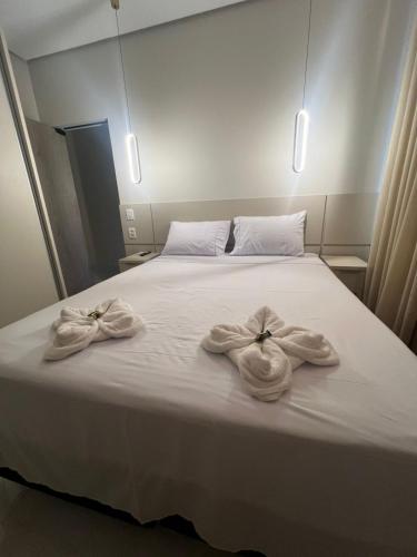a bed with two towels on top of it at Apartamento Prime 02 in Palmas