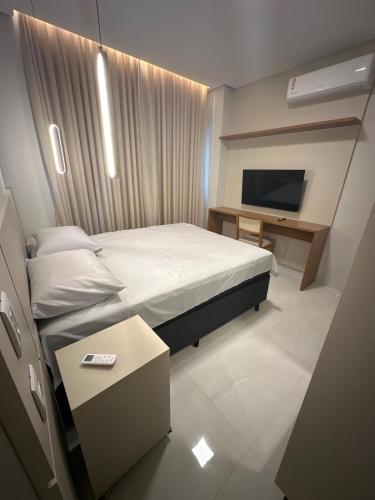 a small bedroom with a bed and a television at Apartamento Prime 02 in Palmas