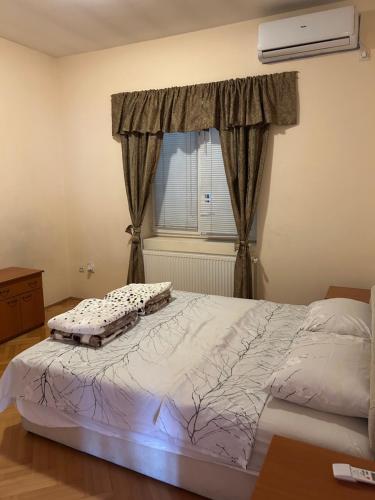 a bedroom with a large bed with a window at Spa Apartment Tamiš River Square in Pančevo