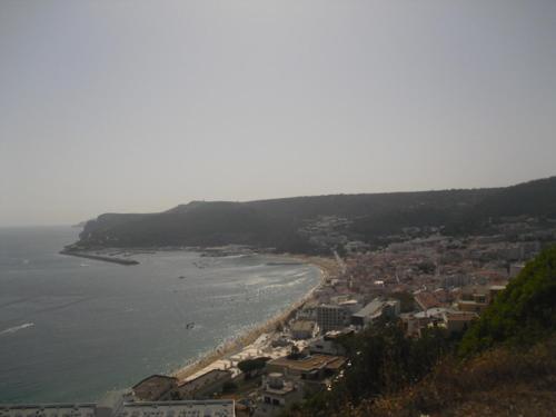 a view of a beach with a town and the ocean at Casa Teresinha in Sesimbra