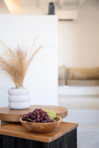 a bowl of grapes on a wooden table at Due Mari Mykonos in Agios Ioannis Mykonos