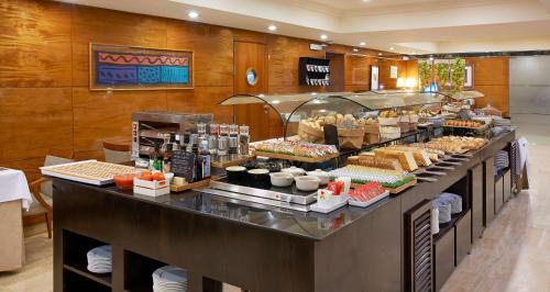 a buffet line with food on display in a restaurant at NH Barcelona Eixample in Barcelona