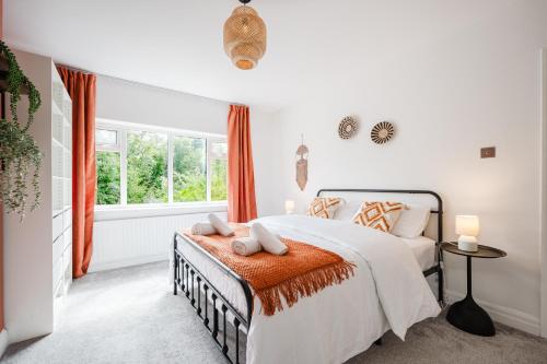a bedroom with a bed and a window at Hilton House - stylish 4-bed with parking in Manchester