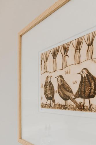 a framed picture of three birds in a field at MUS - Design accommodation with hot tub in Horssen