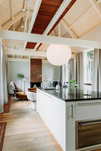 a kitchen with white cabinets and a black counter top at MUS - Design accommodation with hot tub in Horssen