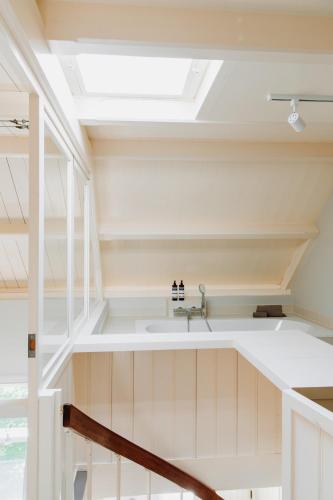 a bathroom with a sink and a skylight at MUS - Design accommodation with hot tub in Horssen