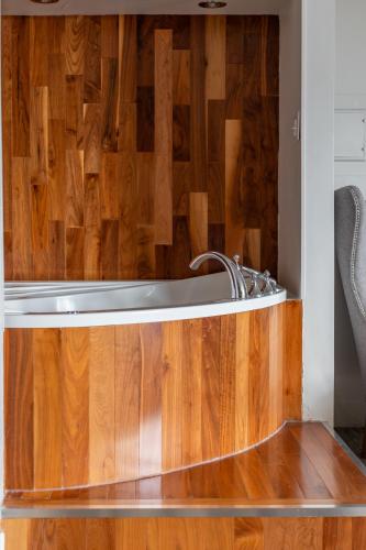 a bathroom with a tub and a wooden floor at Hotel Champlain in Quebec City