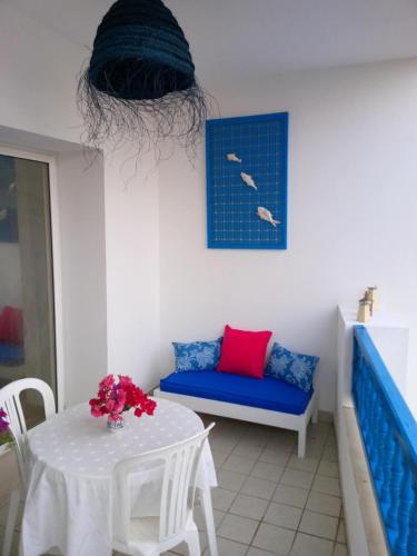 a living room with a table and a blue couch at L'habiba in Hammamet Sud