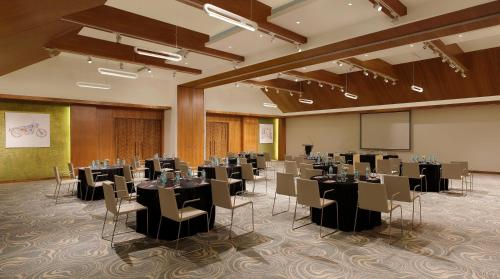 a conference room with tables and chairs and a screen at ibis Styles Goa Calangute - An Accor Brand in Calangute