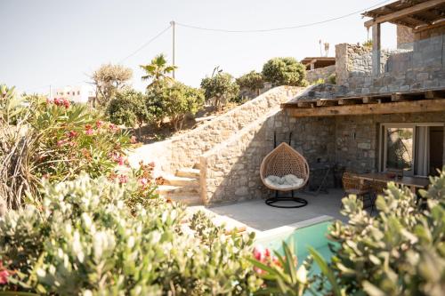 a house with a chair next to a swimming pool at Due Mari Mykonos in Agios Ioannis Mykonos
