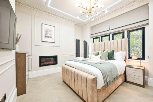 a bedroom with a large bed and a fireplace at 3 Bed Flat-Zone 1-Totthenham Court Rd-Luxury-Families-Groups-Professionals in London