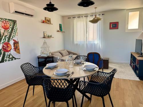 a dining room with a table and chairs in a living room at Le Mahuzies 5 - Hypercentre - 2 Chambres in Castres