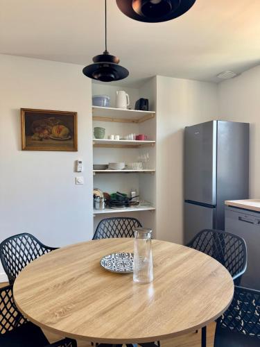 a wooden table in a kitchen with a refrigerator at Le Mahuzies 5 - Hypercentre - 2 Chambres in Castres
