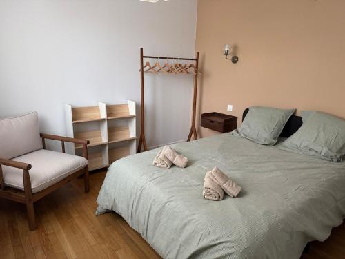 a bedroom with a bed with two pairs of slippers on it at Le Mahuzies 5 - Hypercentre - 2 Chambres in Castres