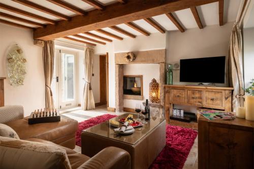a living room with a couch and a tv at Heather Cottage in Kirk Ireton