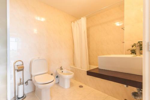 een badkamer met toilet, wastafel en bad bij Vista Mar by Atlantic Holiday in Caniço