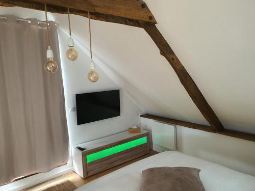 a bedroom with a tv and a bed in a room at Maison De Campagne Proche de La Mer in Brandérion