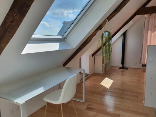 a skylight in a attic room with a desk and a chair at Maison De Campagne Proche de La Mer in Brandérion