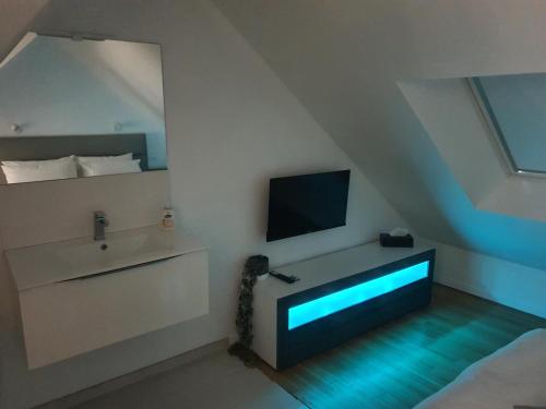 a living room with a tv and a bed at Maison De Campagne Proche de La Mer in Brandérion