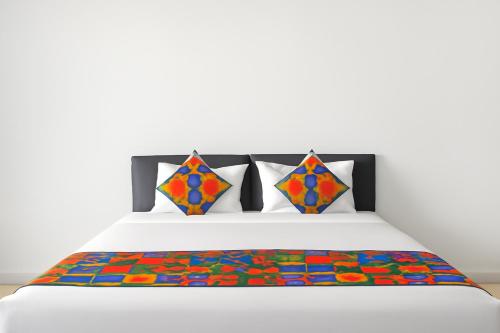 a bed with a colorful blanket and pillows on it at Hotel Grand Stay Park Near Ameerpet Metro Station & GVK One Mall in Hyderabad