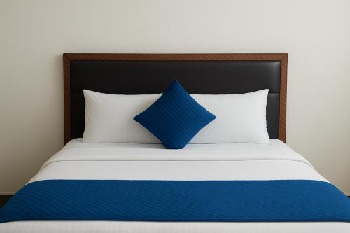 a blue pillow sitting on top of a bed at Hotel Grand Stay Park Near Ameerpet Metro Station & GVK One Mall in Hyderabad