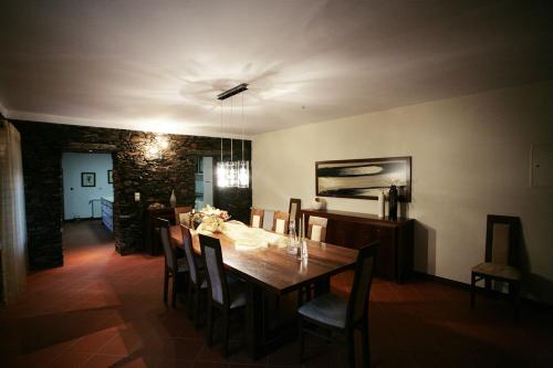 a dining room with a wooden table and chairs at Quinta Madureira in Alfolões