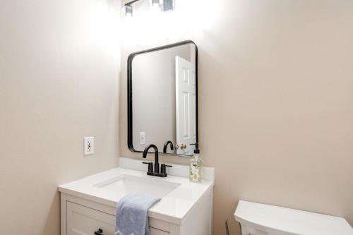 a bathroom with a sink and a mirror at 1 Mi to Ole Miss Pet-Friendly Retreat with Yard in Oxford