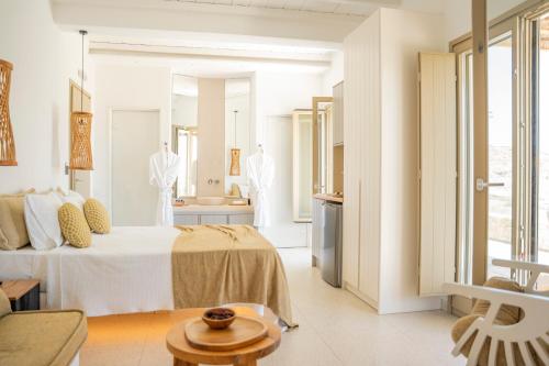 a white room with a bed and a bathroom at Due Mari Mykonos in Agios Ioannis Mykonos