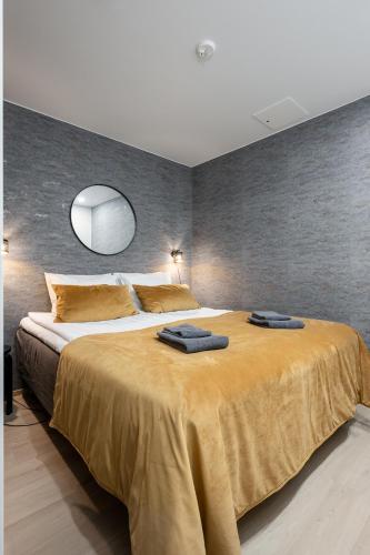 a bedroom with a large bed with two towels on it at City Home Alvari, jäähdytys, ilmainen pysäköinti autohallissa in Kuopio