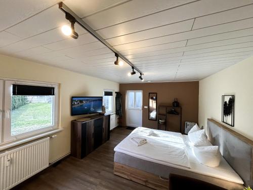 ein Schlafzimmer mit einem Bett und einem Fernseher darin in der Unterkunft Bungalow Strandlicht im Seebad Bansin in Heringsdorf