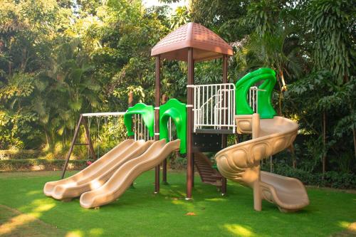 a playground with several slides on a lawn at El Embajador, a Royal Hideaway Hotel in Santo Domingo