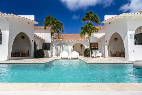 een villa met zwembad en palmbomen bij Nusa B in Jan Thiel