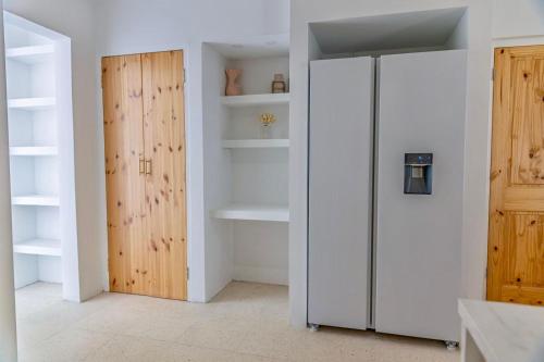 een keuken met een koelkast en een houten deur bij Nusa B in Jan Thiel