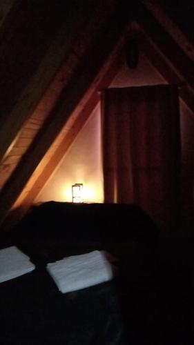 a dark room with a bed and a window at Complejo de Cabañas y Comidas Ruta 43 in Chos Malal