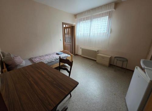 a room with a table and a bed and a table and chairs at Gasthaus für Monteure in Niederzissen