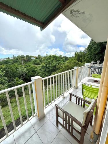 a balcony with a table and a chair on it at Maison charmante avec jardin clos à Sainte-Anne in Sainte-Anne