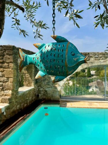 a fish hanging from a chain over a swimming pool at Le Clos du Vialle in Grillon
