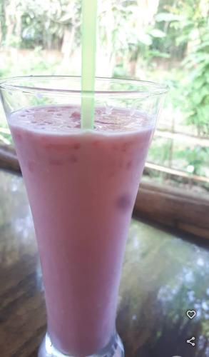 a drink with a straw in a glass on a table at Nishorgo Nirob Eco Resort in Sreemangal