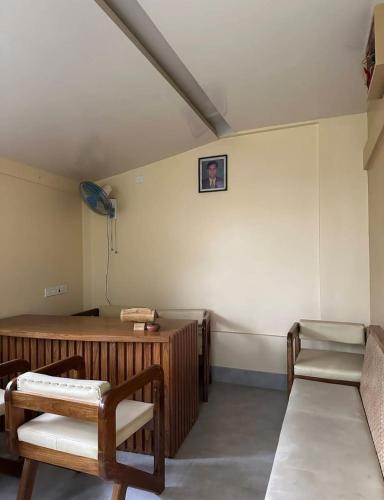 a room with a bench and a table in a room at Nishorgo Nirob Eco Resort in Sreemangal