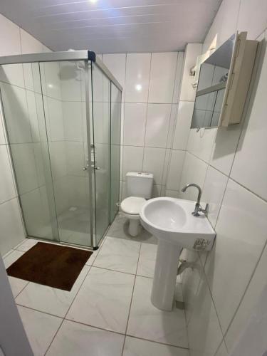 a bathroom with a shower and a sink and a toilet at Vale do Pontal Angra Suites in Angra dos Reis