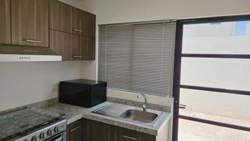 a kitchen with a sink and a stove and a window at Tu espacio ideal en Intercity Urban Corridor in Querétaro