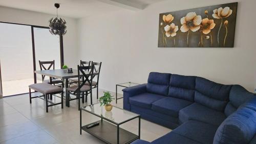 a living room with a blue couch and a table at Tu espacio ideal en Intercity Urban Corridor in Querétaro