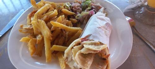 a plate of food with a sandwich and french fries at SIMBA House in Kilifi