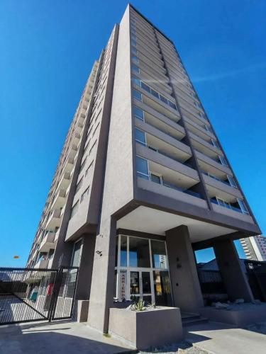 a tall building with a blue sky in the background at Amplio departamento en zona céntrica de Concepción in Concepción